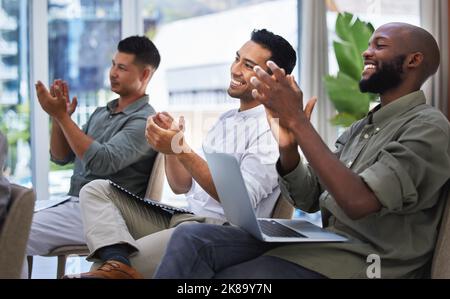 Job Bravo. un gruppo di persone che battono e sorridono durante una riunione al lavoro. Foto Stock