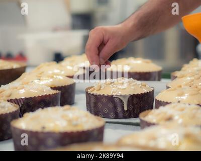 chef topping panettone torta italiana con mandorle Foto Stock