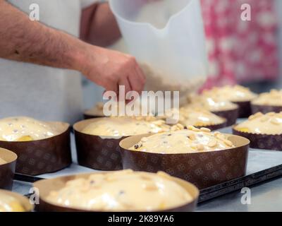 chef topping panettone torta italiana con mandorle Foto Stock