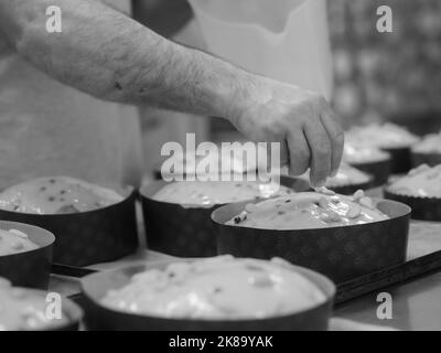 chef topping panettone torta italiana con mandorle Foto Stock