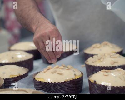 chef topping panettone torta italiana con mandorle Foto Stock