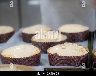 chef topping panettone torta italiana con mandorle Foto Stock