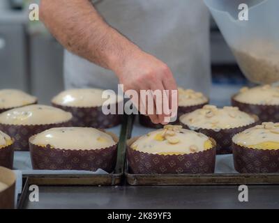 chef topping panettone torta italiana con mandorle Foto Stock