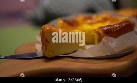 Selezionato focus basco torta di formaggio bruciato su piatto di legno. Foto Stock