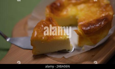 Selezionato focus basco torta di formaggio bruciato su piatto di legno. Foto Stock