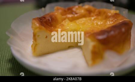 Selezionato focus basco torta di formaggio bruciato su piatto di legno. Foto Stock