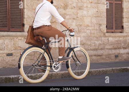 In viaggio verso un altro giorno di successo. Ripresa da dietro di un giovane uomo d'affari in bicicletta in città. Foto Stock