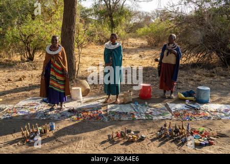 Tarangire, Tanzania - 12th ottobre 2022: Donne Masai che vendono gioielli fatti a mano e ornamenti su una strada all'alba. Foto Stock