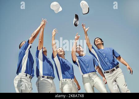 Baseball, cappelli e squadra in festa in una partita, solidarietà per lo sport e sostegno per la partnership. Gruppo di amici atleti che lanciano cappellini per Foto Stock