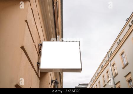 Insegna vuota fuori da un negozio o un ristorante con spazio per le copie nella vecchia strada della città. Cartello vuoto all'aperto. Foto Stock