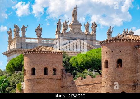 Torri delle Mura Aureliane vicino a porta San Giovanni con sullo sfondo la facciata dell'Arcibasilica di San Giovanni in Laterano, Roma, Italia Foto Stock