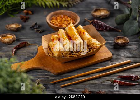 Involtini primavera cinesi fritti con tagliatelle serviti su piatto da asporto Foto Stock