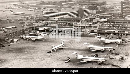 Vista dall'alto delle rampe di parcheggio dell'aeroporto Heathrow di Londra alla fine degli anni sessanta. È possibile identificare diversi tipi di compagnie aeree, in particolare alcune BEA Trident Three AT gate. Foto Stock