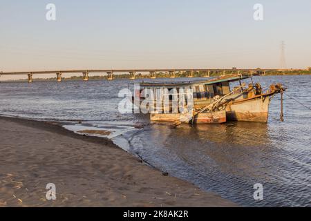 Vecchia barca e un ponte sul Nilo a Dongola, Sudan Foto Stock