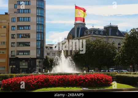 Vista verso l'edificio del Parlamento delle Asturie con una grande fontana di bandiera spagnola e fiori Plaza de la Escandalera Oviedo Asturias Spagna Foto Stock