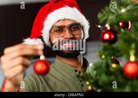 Uomo indiano in cappello di santa decorazione albero di Natale con baubles Foto Stock