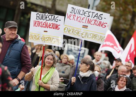 Duesseldorf, Germania. 22nd Ott 2022. Due partecipanti portano con sé cartelloni con l'iscrizione 'Bundestag Verkleinern- Einergi· ·Insparung'. Un'alleanza sociale ha richiesto dimostrazioni a livello nazionale, chiedendo ulteriori misure di aiuto a breve termine, un tetto massimo per i prezzi dell'elettricità e del gas, ulteriori sussidi per l'energia e la fine della dipendenza dai combustibili fossili. Credit: David Young/dpa/Alamy Live News Foto Stock