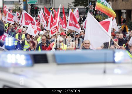 Duesseldorf, Germania. 22nd Ott 2022. Durante la dimostrazione, i partecipanti con bandiere camminano lungo una strada. Il rally è accompagnato dalla polizia. Un'alleanza sociale ha richiesto dimostrazioni a livello nazionale, chiedendo ulteriori misure di aiuto a breve termine, un tetto massimo per i prezzi dell'elettricità e del gas, ulteriori sussidi per l'energia e la fine della dipendenza dai combustibili fossili. Credit: David Young/dpa/Alamy Live News Foto Stock