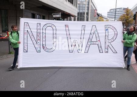 Duesseldorf, Germania. 22nd Ott 2022. Due manifestanti portano una bandiera con l'iscrizione "NESSUNA GUERRA". Un'alleanza sociale ha richiesto dimostrazioni a livello nazionale, chiedendo ulteriori misure di aiuto a breve termine, un tetto massimo per i prezzi dell'elettricità e del gas, ulteriori sussidi per l'energia e la fine della dipendenza dai combustibili fossili. Credit: David Young/dpa/Alamy Live News Foto Stock