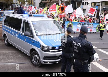 Duesseldorf, Germania. 22nd Ott 2022. Durante la dimostrazione, i partecipanti con bandiere camminano lungo una strada. Il rally è accompagnato dalla polizia. Un'alleanza sociale ha richiesto dimostrazioni a livello nazionale, chiedendo ulteriori misure di aiuto a breve termine, un tetto massimo per i prezzi dell'elettricità e del gas, ulteriori sussidi per l'energia e la fine della dipendenza dai combustibili fossili. Credit: David Young/dpa/Alamy Live News Foto Stock