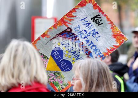 Duesseldorf, Germania. 22nd Ott 2022. Un dimostratore mostra un cartello con la scritta "No trade with dittators. Putin fuori dall’Ucraina”. Un'alleanza sociale ha richiesto dimostrazioni a livello nazionale, chiedendo ulteriori misure di aiuto a breve termine, un tetto massimo per i prezzi dell'elettricità e del gas, ulteriori sussidi per l'energia e la fine della dipendenza dai combustibili fossili. Credit: David Young/dpa/Alamy Live News Foto Stock