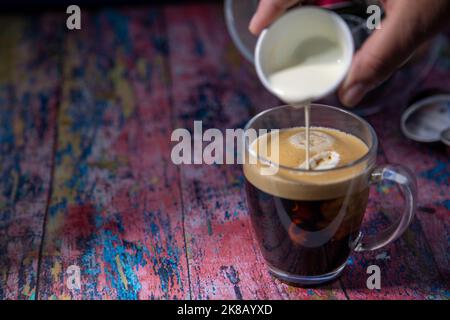 Americano con panna versata in bevanda Foto Stock