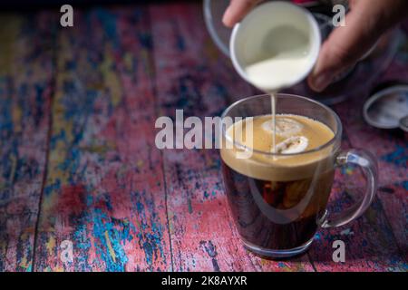 Americano con panna versata in bevanda Foto Stock