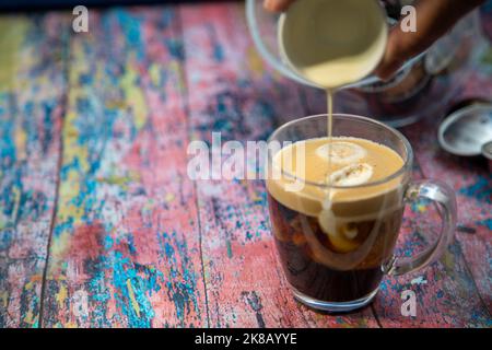 Americano con panna versata in bevanda Foto Stock