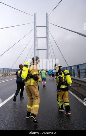 22 ottobre 2022, Meclemburgo-Pomerania occidentale, Stralsund: Andre Lippisch (l-r) da Cobbelsdorf vicino a Wittenberg e Steven Dreher da Schönebeck an der Elbe stanno iniziando come vigili del fuoco dai loro reparti di vigili del fuoco volontari. Tra le altre cose, stanno correndo per i bambini affetti da cancro, e lo stanno facendo in piena attrezzatura antincendio. Il ponte Rügen attraversa il nuovo ponte Rügen di Stralsund e Altefähr, inaugurato nel 2007. Con oltre 3500 partecipanti, la maratona di Rügenbrücken è uno dei più grandi eventi sportivi del Meclemburgo-Pomerania anteriore. Ci sono un totale di sette Foto Stock