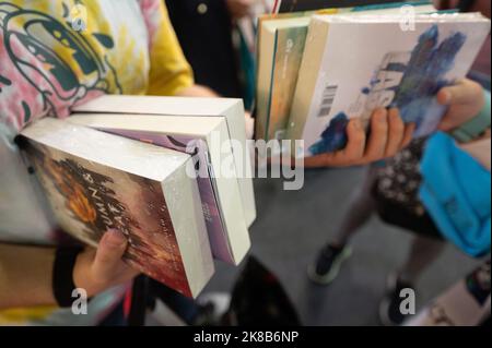 22 ottobre 2022, Hesse, Francoforte sul meno: Un uomo tiene libri alla Fiera del Libro di Francoforte. La Fiera del Libro è aperta a tutti i visitatori da ottobre 21. Continua fino a ottobre 23. Foto: Sebastian Gollnow/dpa Foto Stock