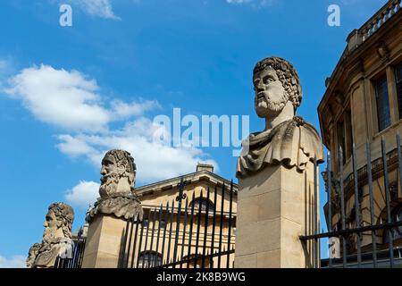 Tre dei busti di pietra noti come "le teste dell'imperatore" fuori del teatro di Sheldonian, Broad St, Università di Oxford, Oxford, Oxfordshire, Inghilterra. Foto Stock