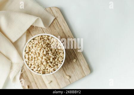 vista dall'alto dei pinoli su una ciotola di colore bianco Foto Stock