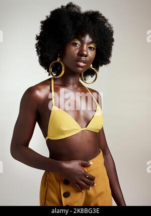 Moda gialla, trucco e bellezza con una modella donna nera in studio su uno sfondo grigio per una fotografia contemporanea. Cosmetici, accessori e. Foto Stock