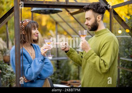 Coppia appendere insieme al vino in giardino Foto Stock