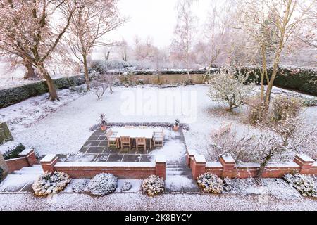 Giardino coperto di neve in inverno, Regno Unito. Grande cortile o giardino di campagna nella scena invernale Foto Stock