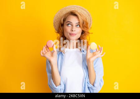 ritratto di elegante bella carina lei sua ragazza con dolci biscotti macaroon isolato su sfondo giallo. Foto Stock