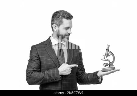 uomo d'affari puntando dito sul microscopio moderno isolato su bianco, scienza e commercio. Foto Stock