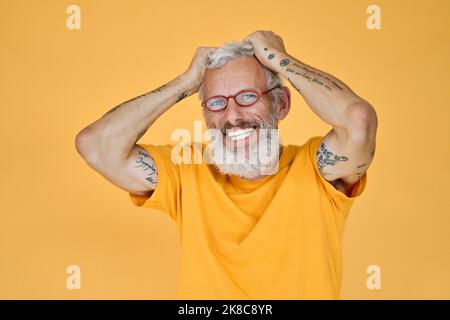 Felice divertente più vecchio uomo portatore con gli occhiali isolato sul giallo. Foto Stock