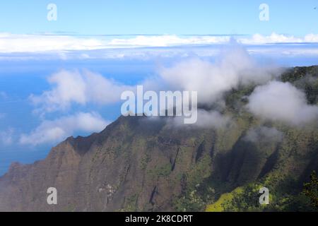 Guardando giù a scoscese scogliere, alcuni aridi e alcuni coperti di alberi e vegetazione, cumuli nuvole e l'Oceano Pacifico dal pu'u o Kila lo Foto Stock