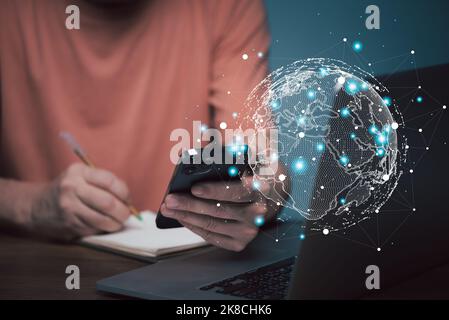 Concetto di e learning. Uomo d'affari casual che studia il corso in linea via il calcolatore del laptop e la scrittura sul taccuino. Foto Stock