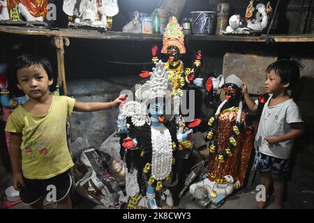 Kolkata, Bengala Occidentale, India. 22nd Ott 2022. I bambini giocano con gli idoli Kali all'interno di un laboratorio in vista del festival Kali Puja di Kolkata. Credit: ZUMA Press, Inc./Alamy Live News Foto Stock