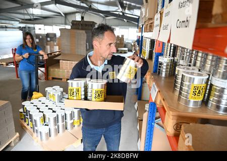 Rielasingen, Germania. 19th Ott 2022. Philipp Nater (r), Amministratore Delegato di SicherSatt AG, confeziona nel magazzino i pacchi di scorte di emergenza, mentre Brigitte, Vice Amministratore Delegato di SicherSatt, gestisce in background un transpallet. 51.931 calorie sono contenute nel magazzino di emergenza 'Classic'. Secondo il produttore 'SicherSatt', fornisce abbastanza cibo per nutrire una persona per 30 giorni. (A dpa: "Stai ancora acquistando o stai già accumulando? - Forniture di emergenza prima dell'inverno') Credit: Felix Kästle/dpa/Alamy Live News Foto Stock