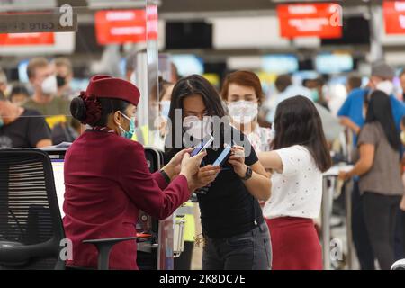 Bangkok, Thailandia - 26 ottobre 2022 : passeggeri asiatici che utilizzano lo smartphone per effettuare il check-in presso lo sportello delle compagnie aeree dell'aeroporto suvarnabhumi, Thailandia. Foto Stock