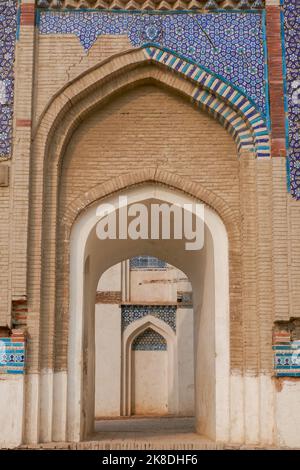 Vista degli archi in perpettiva presso l'antica tomba medievale di Bibi Jawindi con decorazione in ceramica blu, unità Centrale Abitacolo Sharif, Bahawalpur, Punjab, Pakistan Foto Stock