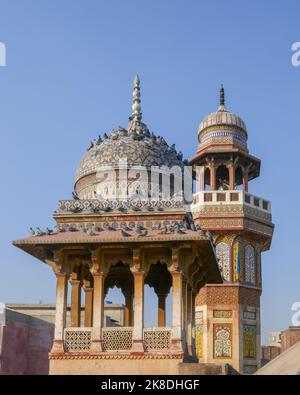Vista del minareto e del chiosco con piccioni visti dal tetto del punto di riferimento mughal era moschea Wazir Khan nella città murata di Lahore, Punjab, Pakistan Foto Stock