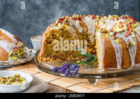 Fragrante torta d'amore persiana decorata con glassa alla vaniglia, pistacchi schiacciati e petali di rosa secchi Foto Stock