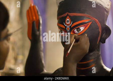 artista che dipinge l'occhio dell'idolo della dea kali per il festival di kalipuja in india, celebrato durante diwali. Foto Stock