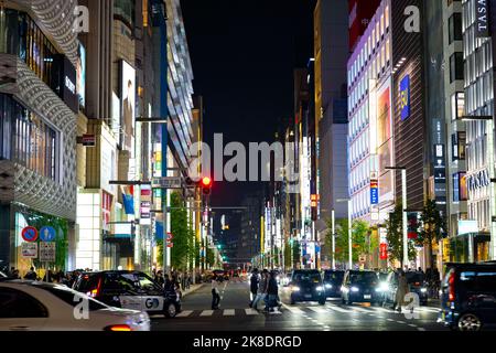 Tokyo, Giappone. 22nd Ott 2022. Scene di strada generali di notte di un importante incrocio a Ginza con attraversamento pedonale. Ginza è un popolare quartiere di shopping di lusso noto per la sua selezione di negozi al dettaglio di lusso e ricchezza simile alla Fifth Avenue. E' adiacente alla Citta' di Chiyoda, sede del Palazzo Imperiale e sede del Governo Giapponese. Il Giappone ha recentemente riaperto al turismo dopo oltre due anni di divieti di viaggio a causa della pandemia COVID-19. Lo Yen si è notevolmente deprezzato nei confronti del dollaro USA, creando turbolenze economiche per il commercio internazionale e l'economia giapponese. Turisti Foto Stock