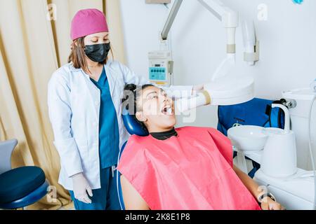 Dentista che esegue la radiografia intraorale dentale su un paziente, dentista che esegue la valutazione intraorale della radiografia su un paziente, dentista che esegue la radiografia intraorale Foto Stock