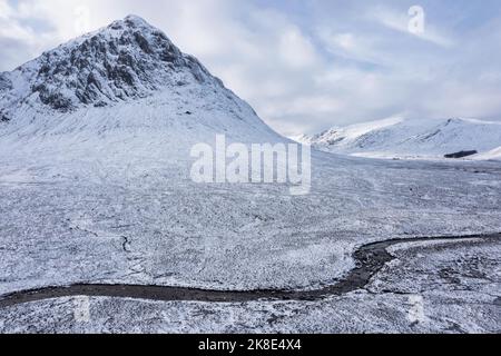 Splendida immagine aerea del paesaggio dei droni di Stob Dearg e Glencoe nelle Highlands scozzesi durante le profonde nevicate e i bellissimi cieli blu Foto Stock